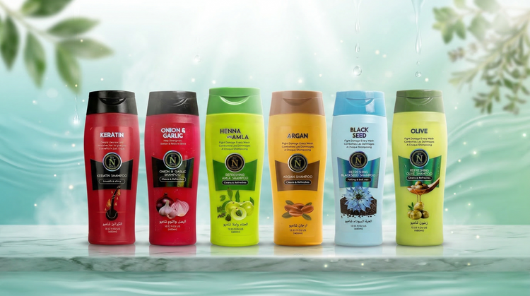 Noor Gold shampoo collection featuring keratin, onion and garlic, henna and amla, argan, black seed, and olive variants displayed on a marble surface with a fresh botanical background.