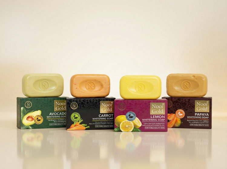 Noor Gold whitening soap collection featuring avocado, carrot, lemon, and papaya variants displayed with product boxes on a soft neutral background.