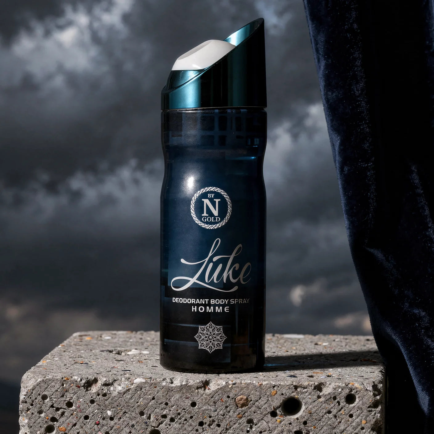 Deodorant body spray bottle labeled 'Luke' by N Gold on a concrete block with a dark background.
